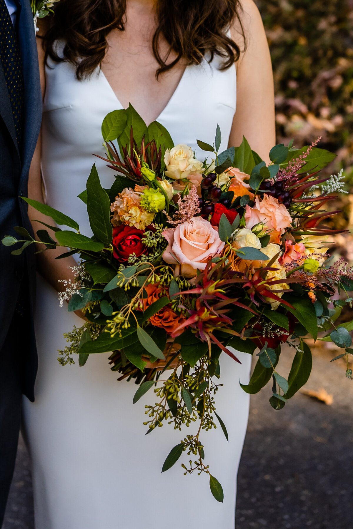  Bride holding colorful bouquet with orange and blush florals