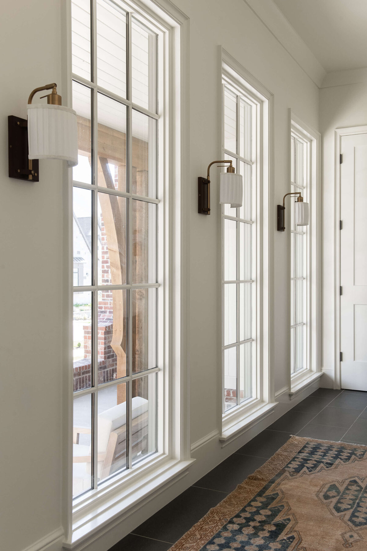 dutch-tudor-hallway-with-tall-windows-and-sconces