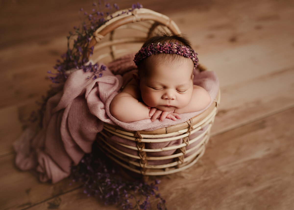 How sweet is baby laying in a basket full of flowrs in Syracuse New York