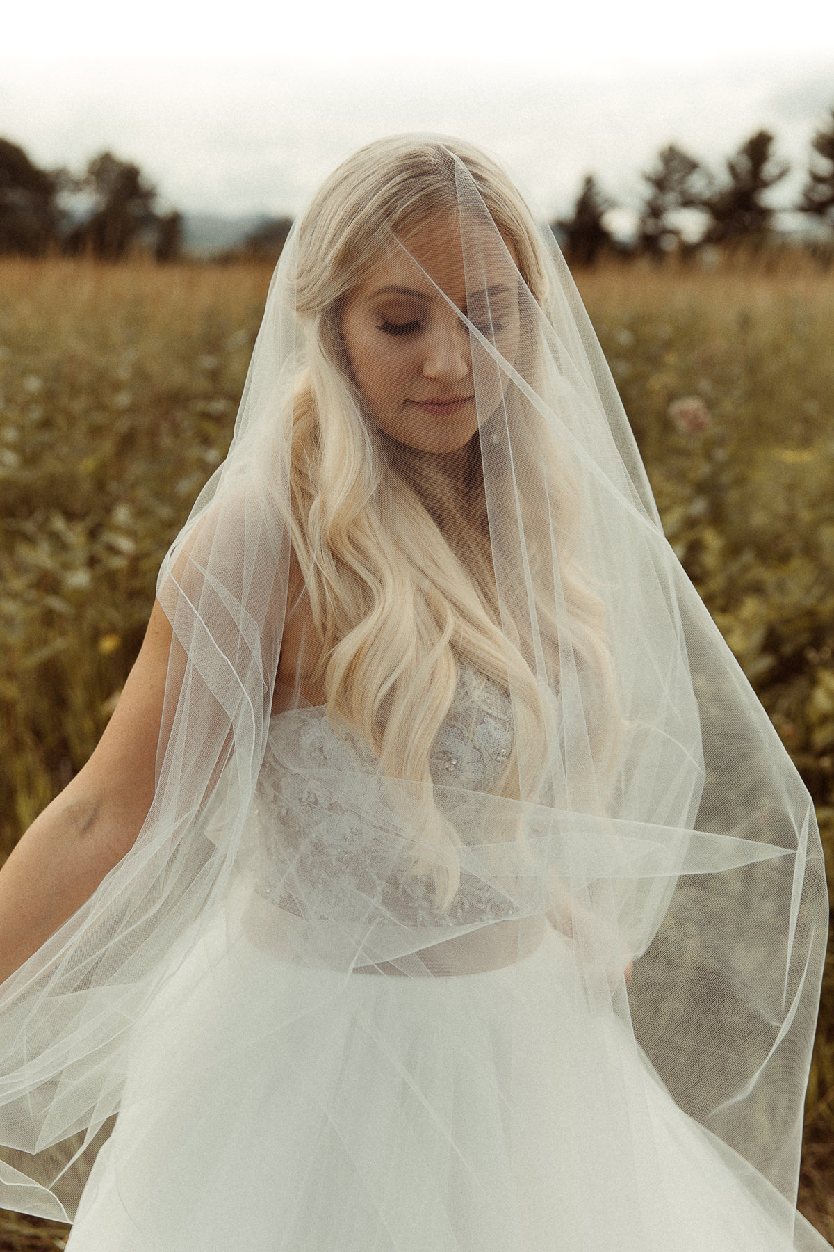 bride spins in a field with her veil over her face