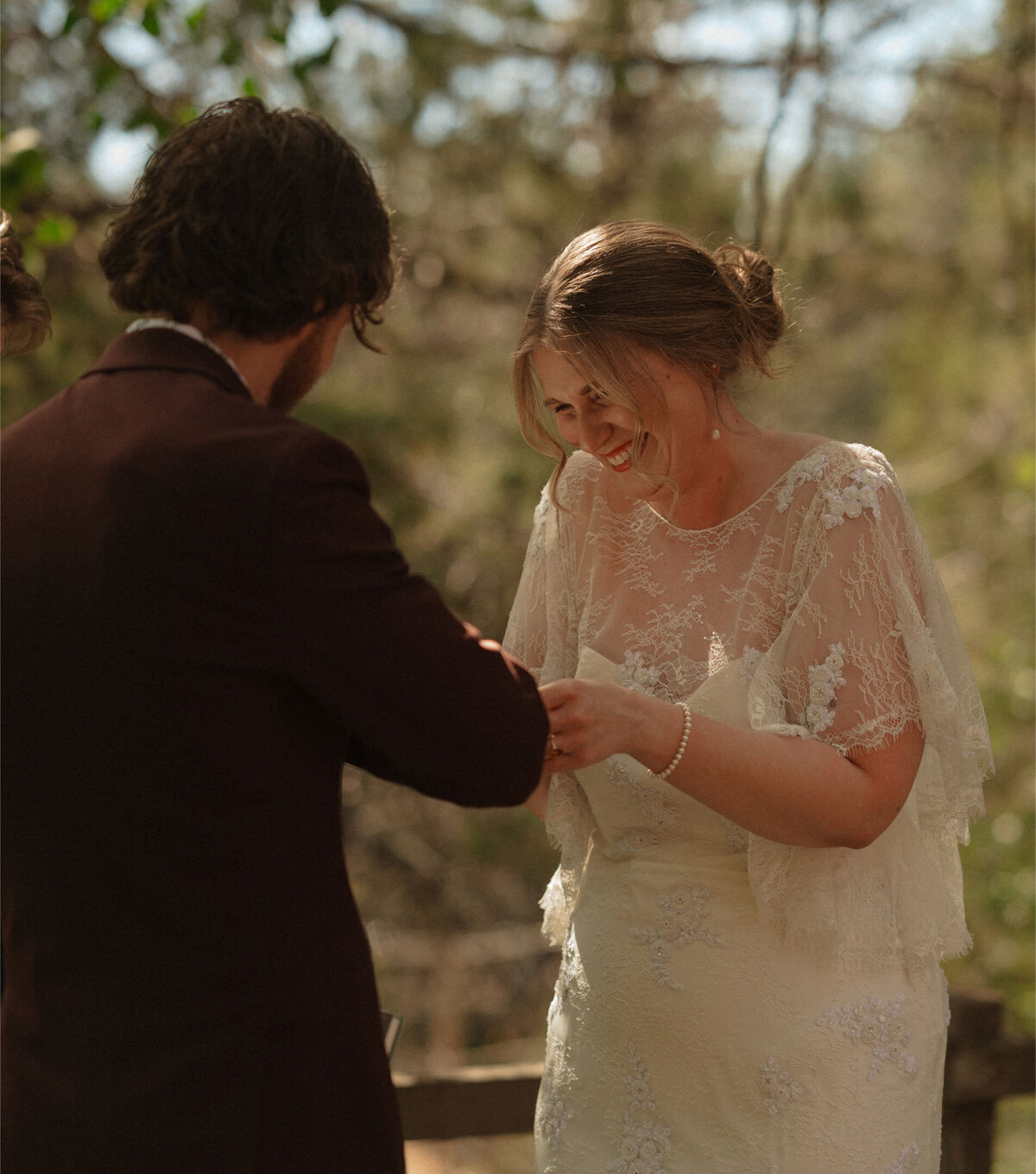 bride and groom share a fun and silly moment as they exchange vows at their elopement under the green trees in Bend, Oregon