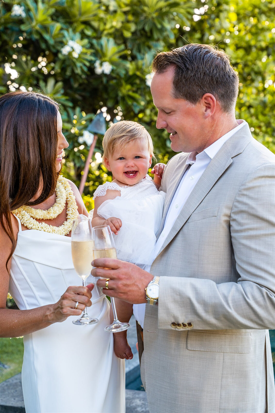 kona wedding photography with couple holding their baby