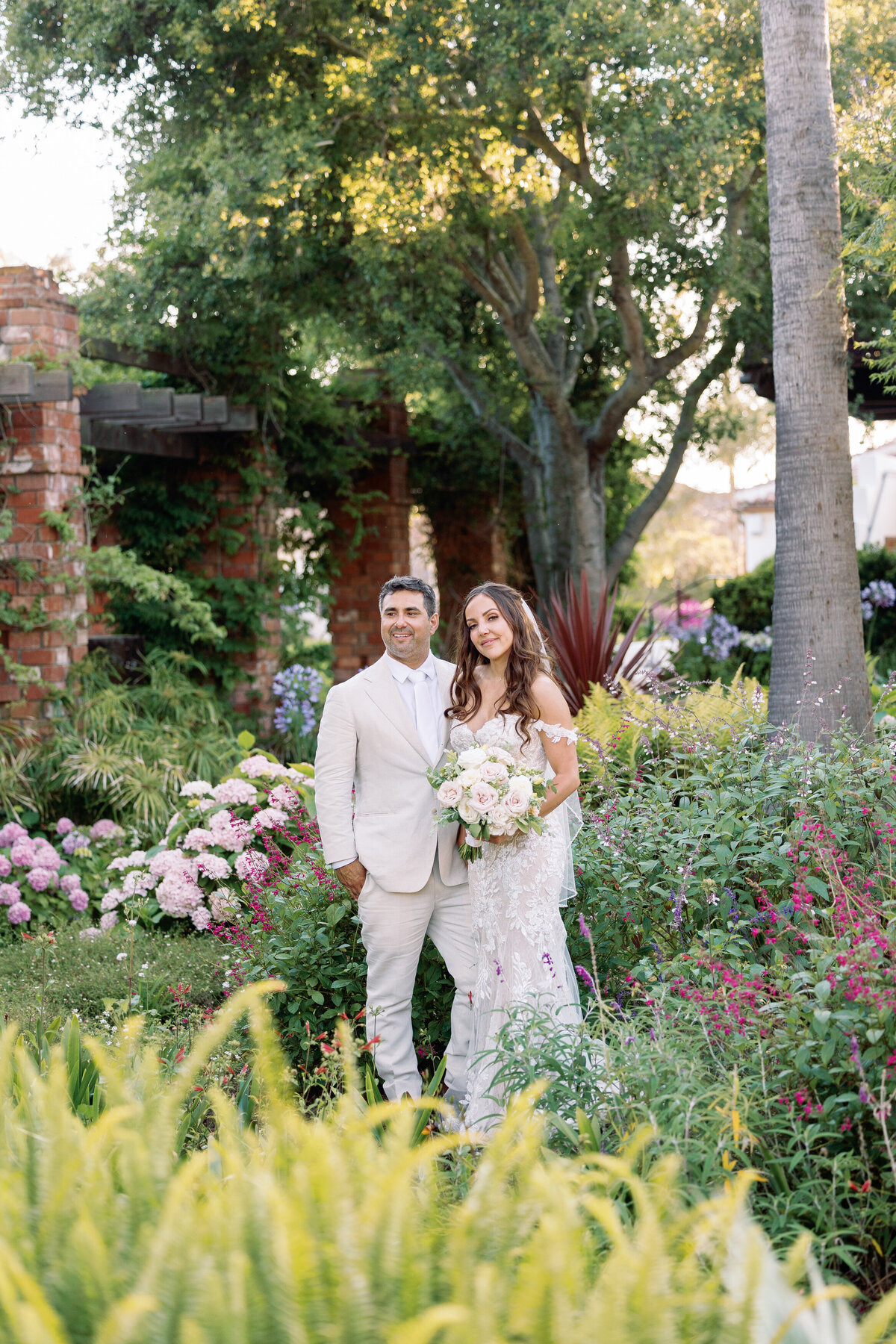 Bride and groom standing on the gardens of the Belmond El Encanto