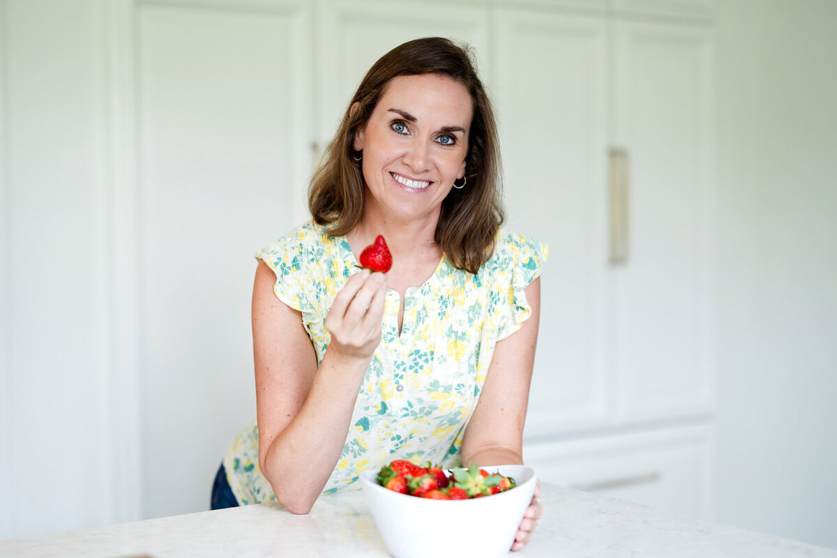 a woman holding a strawberry