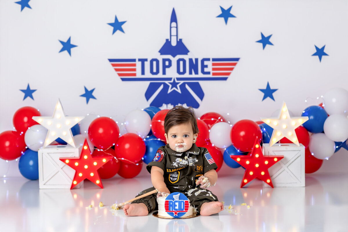 One year old Tampa baby enjoying a personalized luxury cake smash session with top ONE decorations