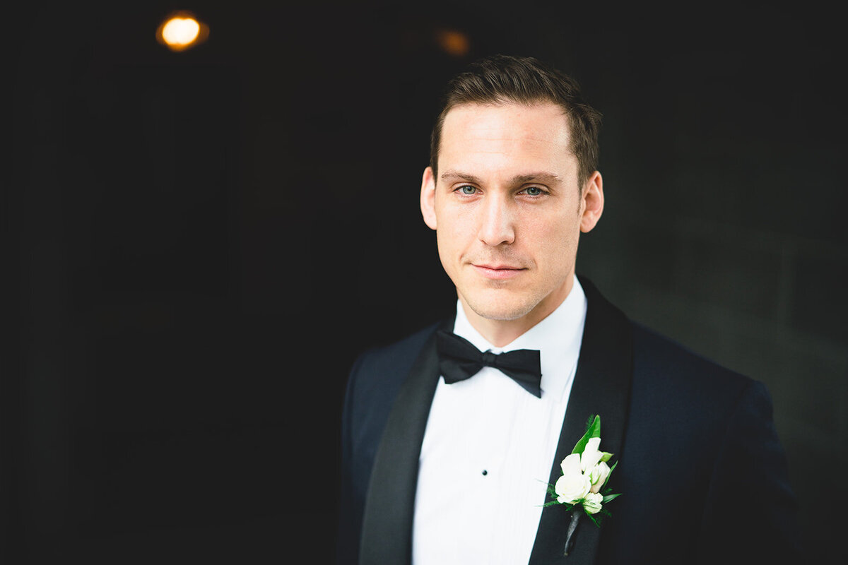 The groom is looking towards camera in a portrait photograph