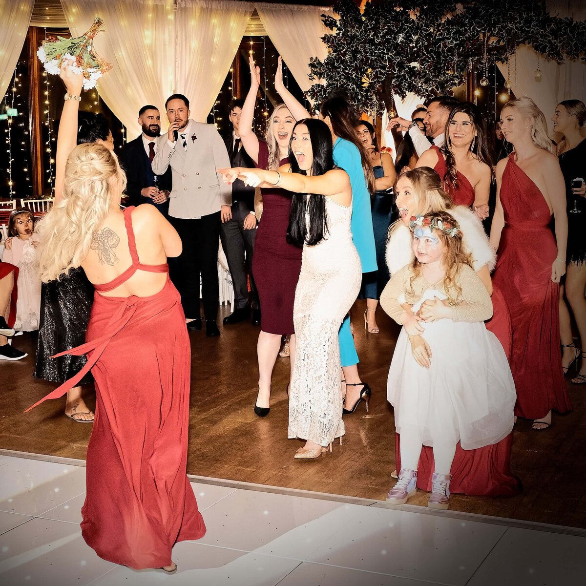 Bridesmaids fun reaction during the tossing of the bouquet at a wedding.