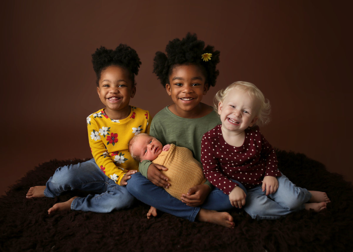 family portrait with three older children and one newborn