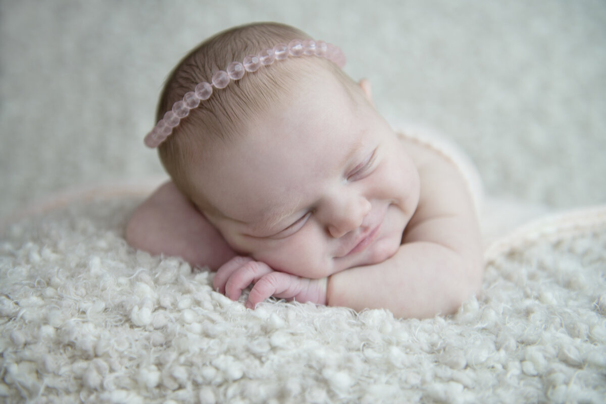 Newborn baby girl sleeping with beaded headband