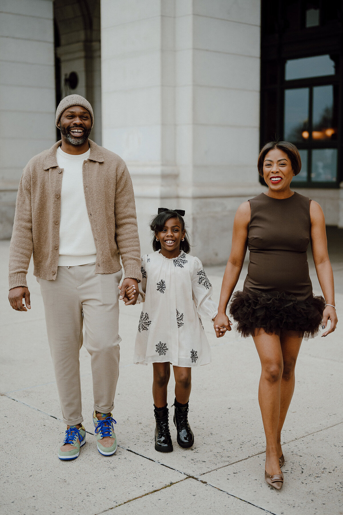 Family holding hands walking towards the camera 