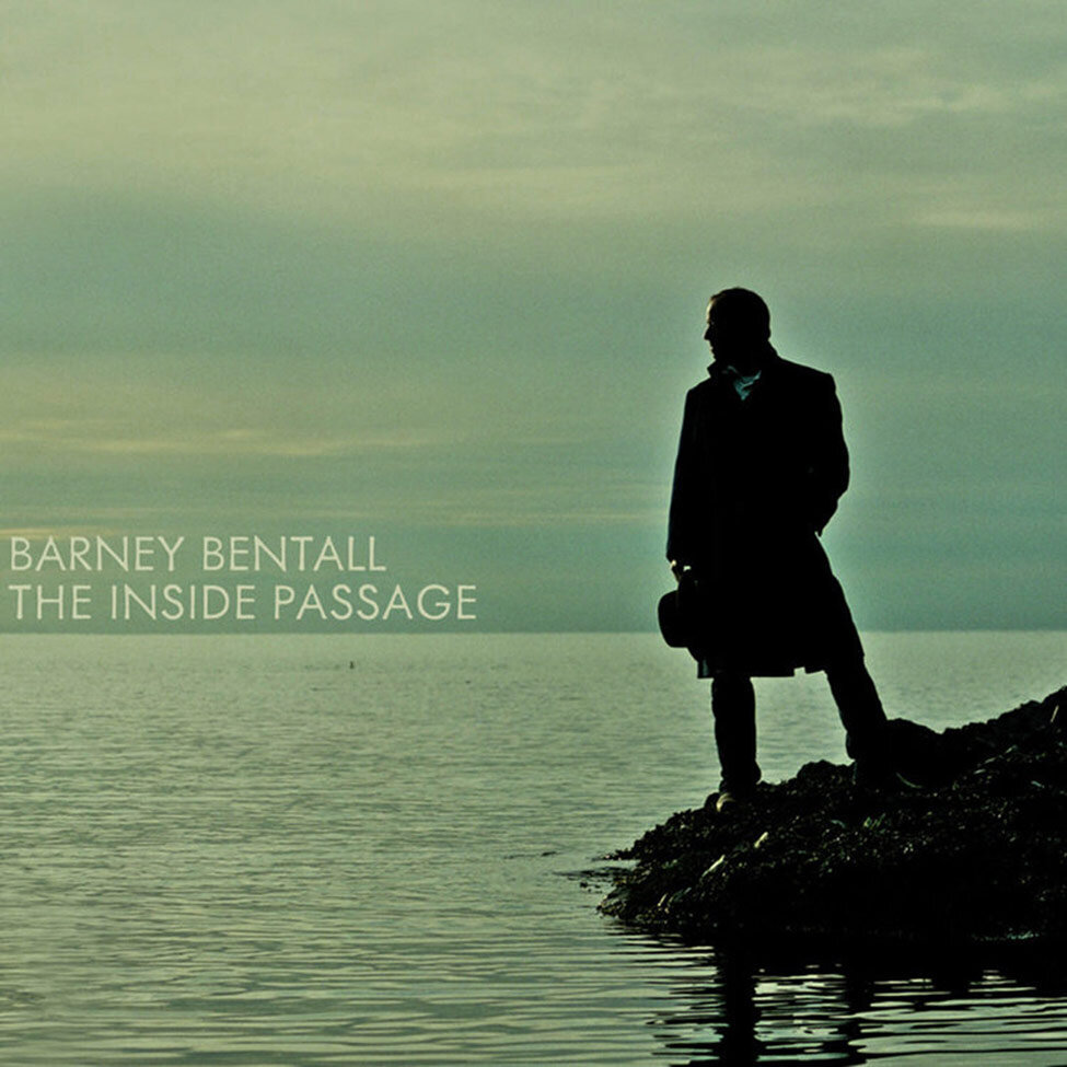 Album Cover featuring Barney Bentall standing on rocks next to water Title The Inside Passage