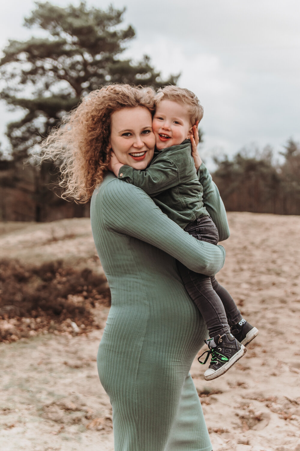 Vrouw zwanger met zoon lachend