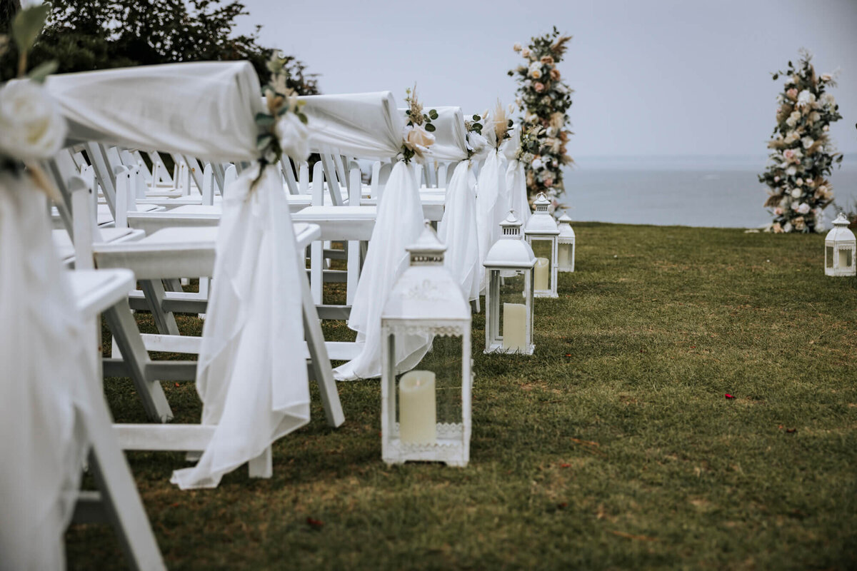 A row of white chairs sitting on top of a lush green lawn