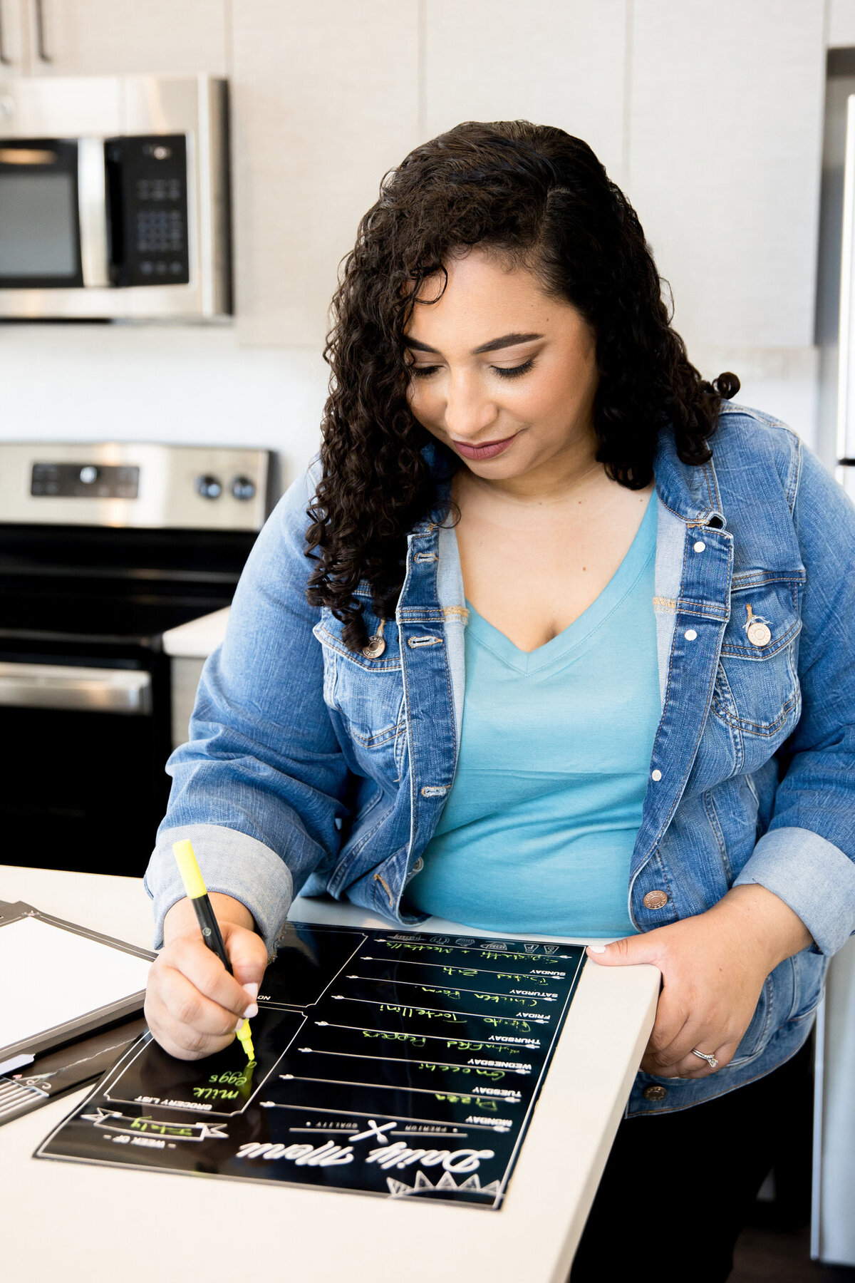 Heather’s personal branding photo writing on a planner highlights organization and planning.