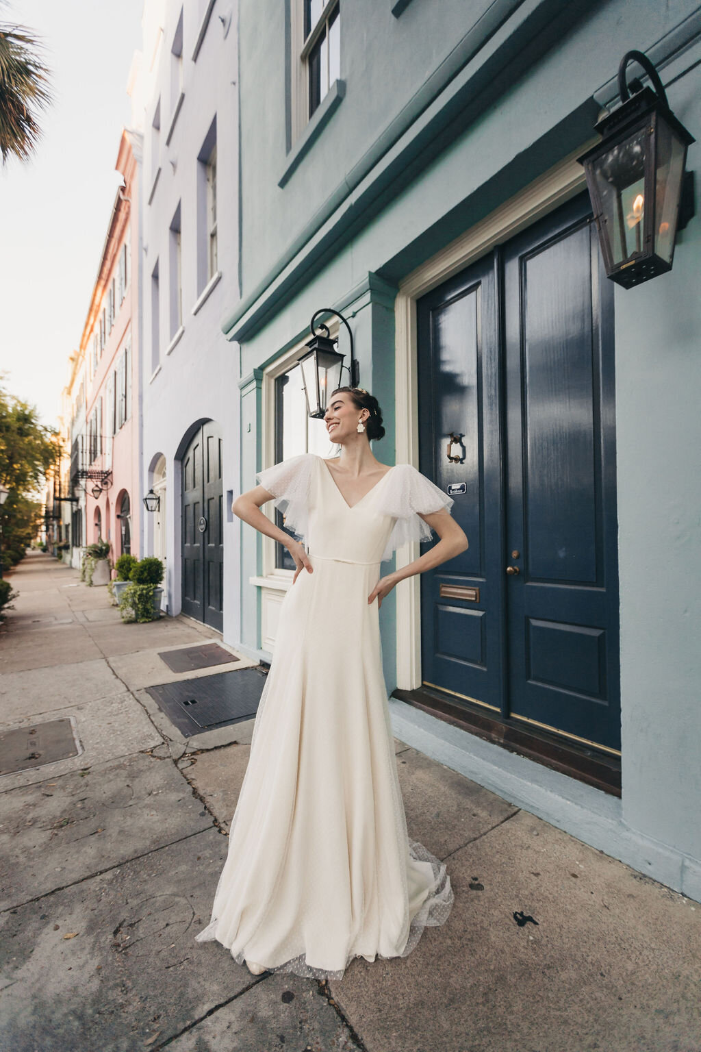 The v-neck, modified a-line silhouette of the Mai wedding dress style is paired with dramatic swiss dot net flutter sleeves.