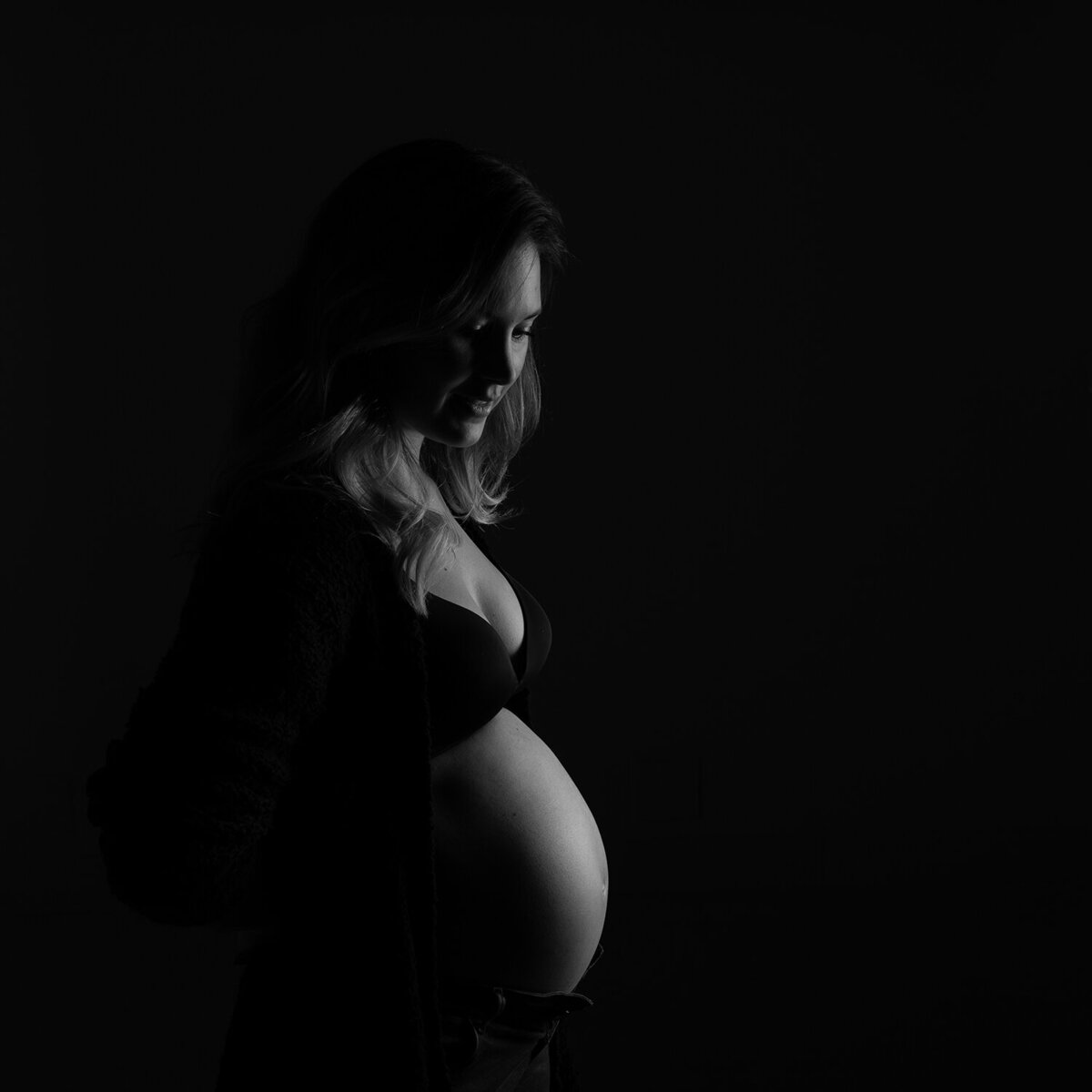 Zwangerschapsfotografie, buikfoto zwarte achtergrond