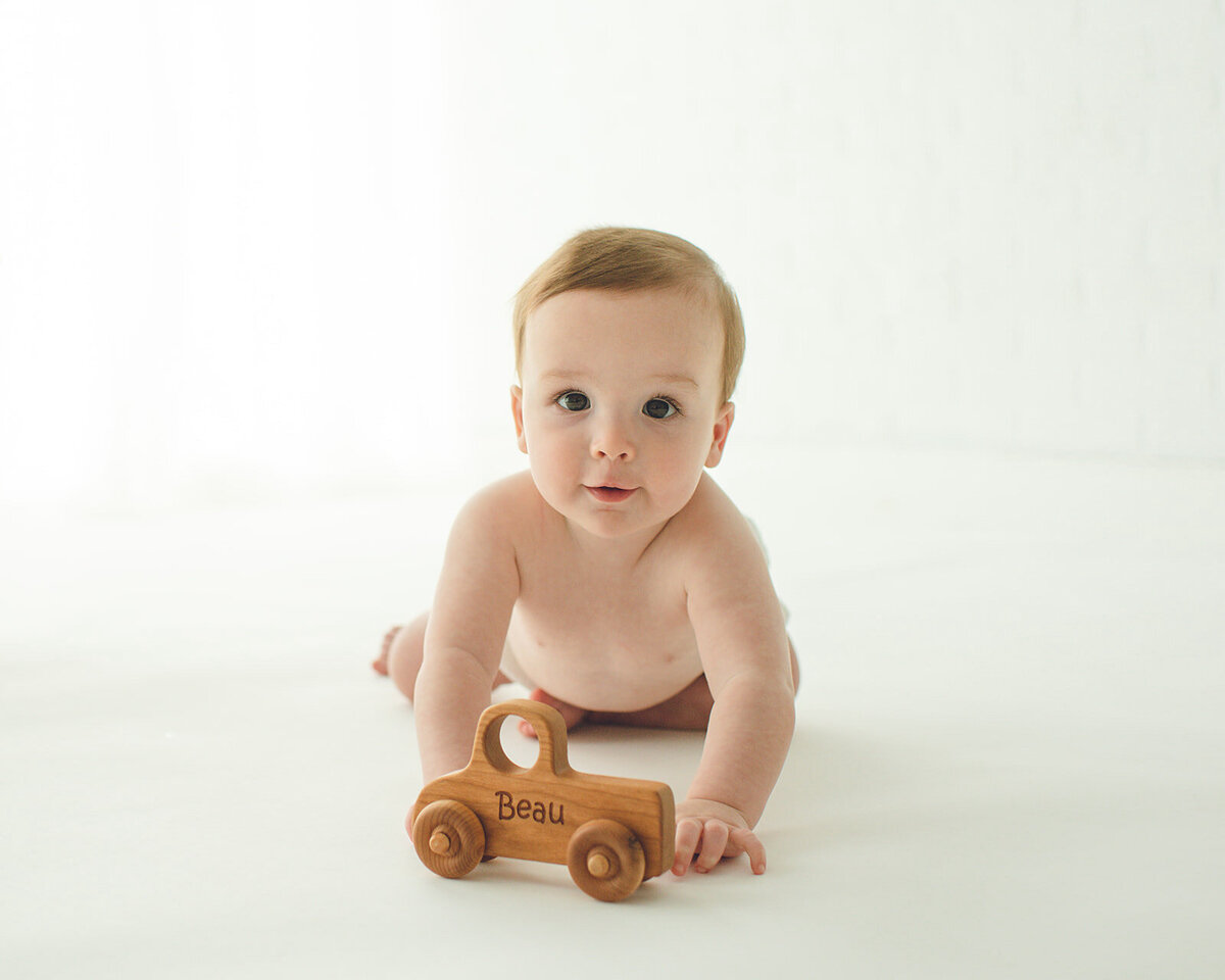 one year old boy with wooden toy truck