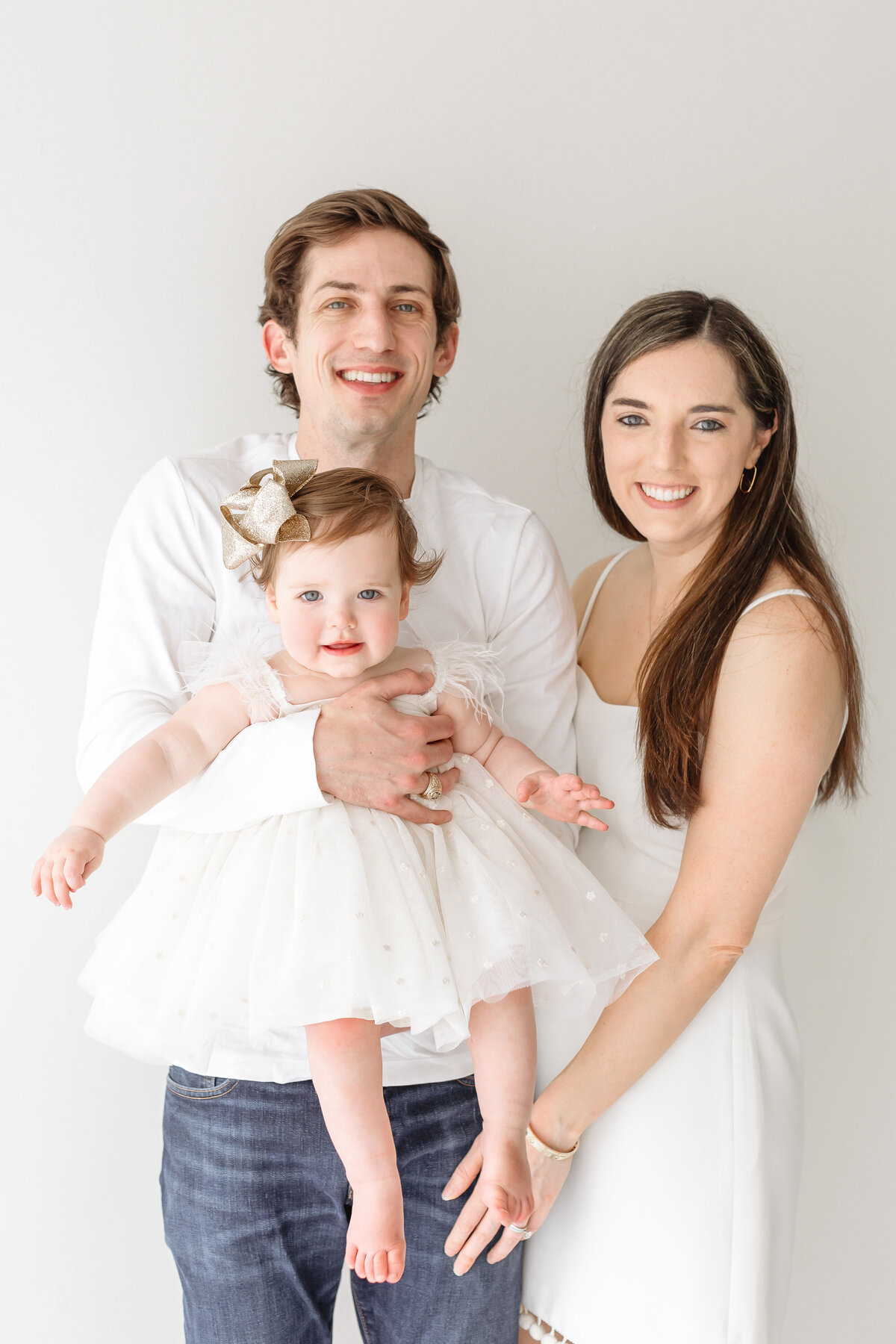 happy parents holding toddler girl