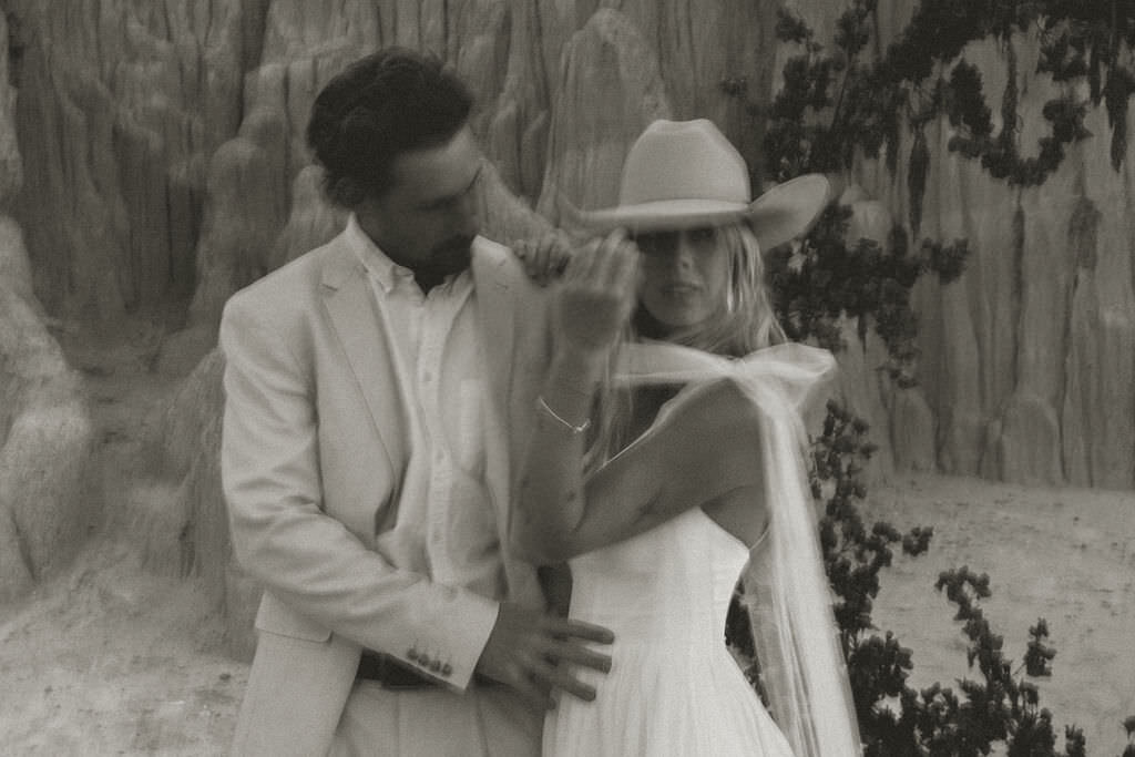 A wedding couple standing together smiling.