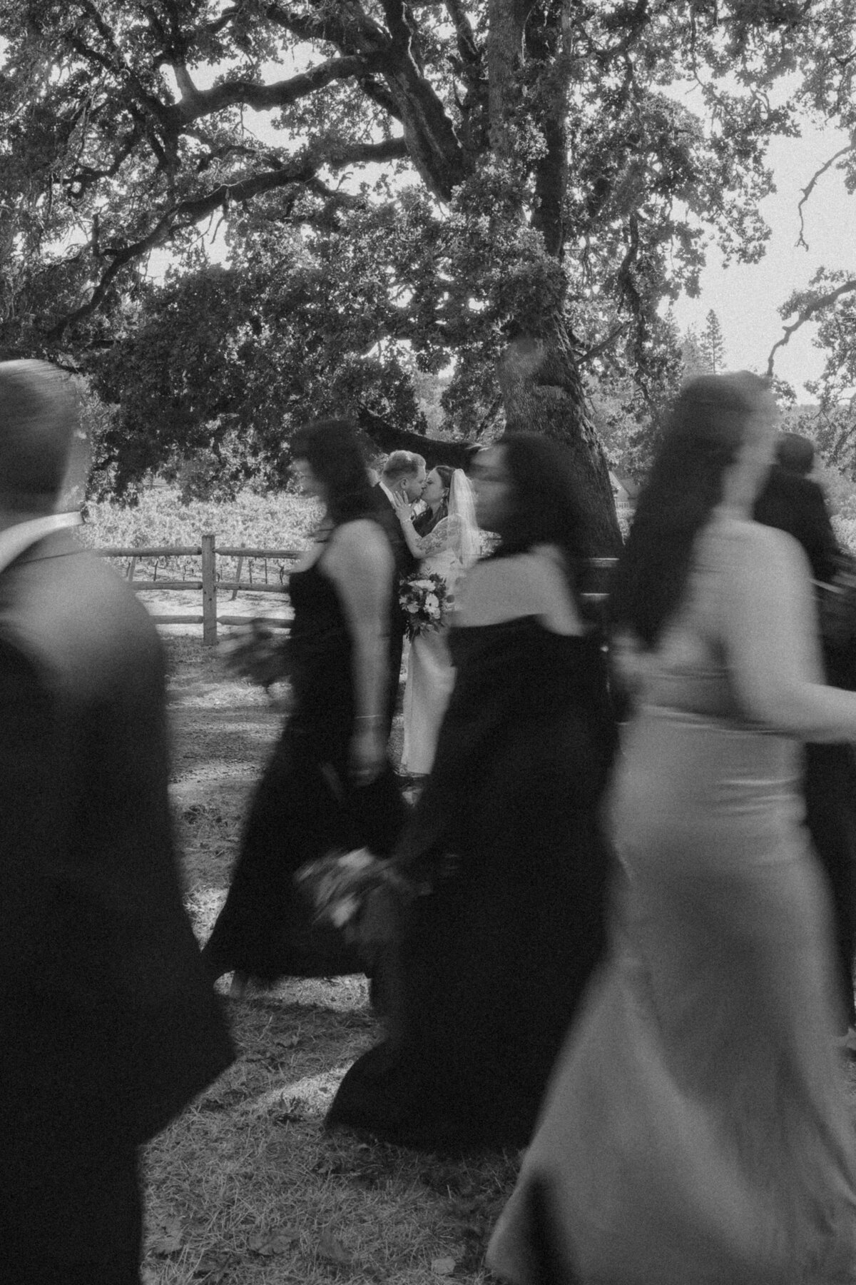 Romantic Wedding Kiss with Bridal Party in Motion | Candid Oregon Wedding Photographer