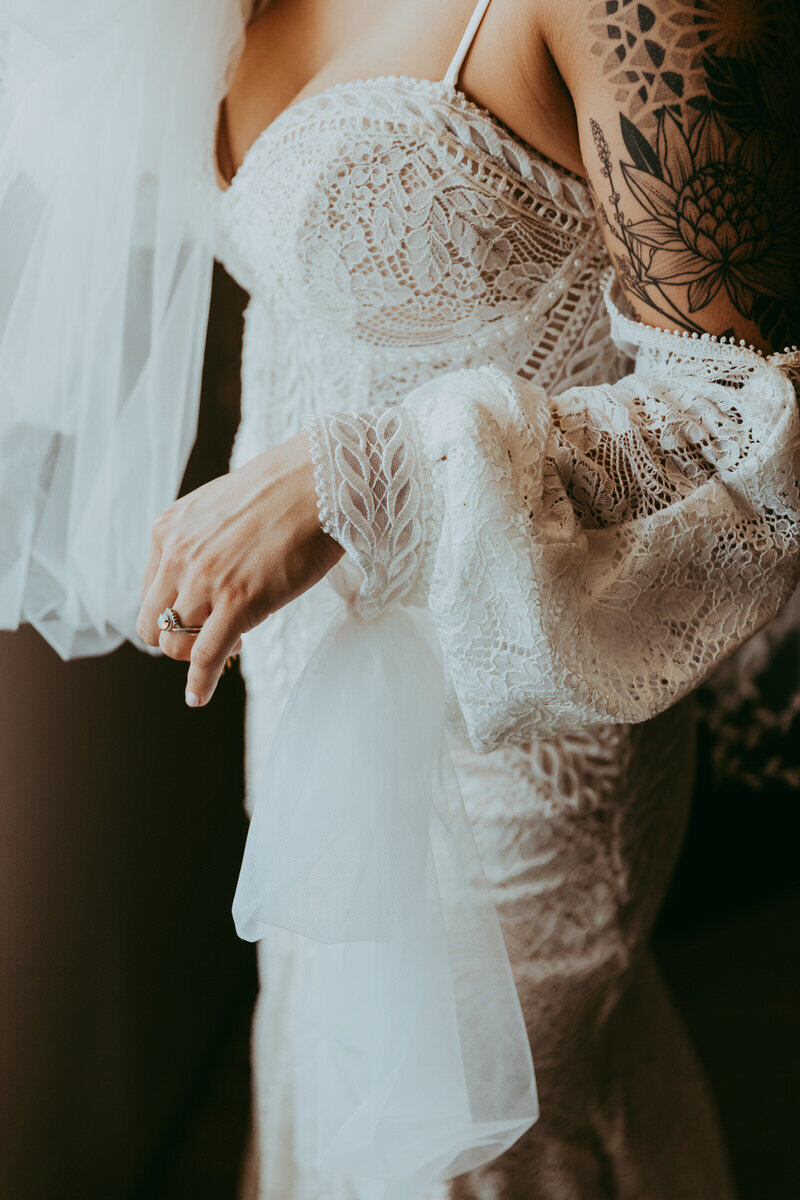 bride holds onto dress in natural light