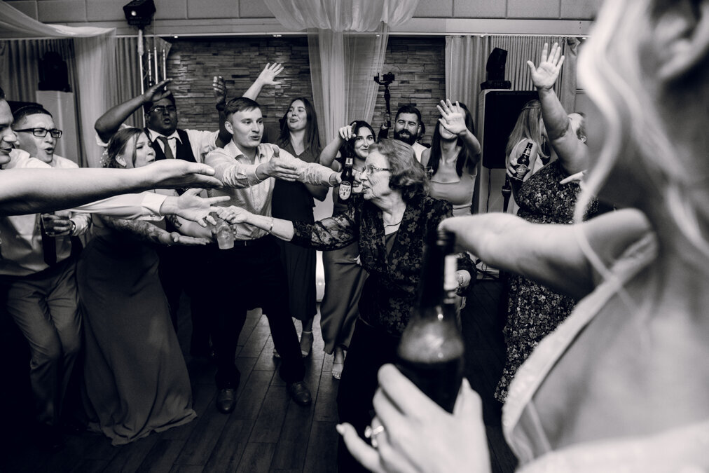 A black and white photo of a group of people dancing at a wedding.