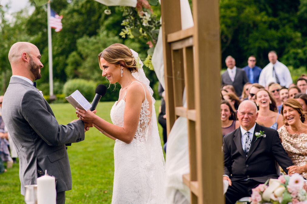 A bride and groom exchange vows in an outdoor ceremony.