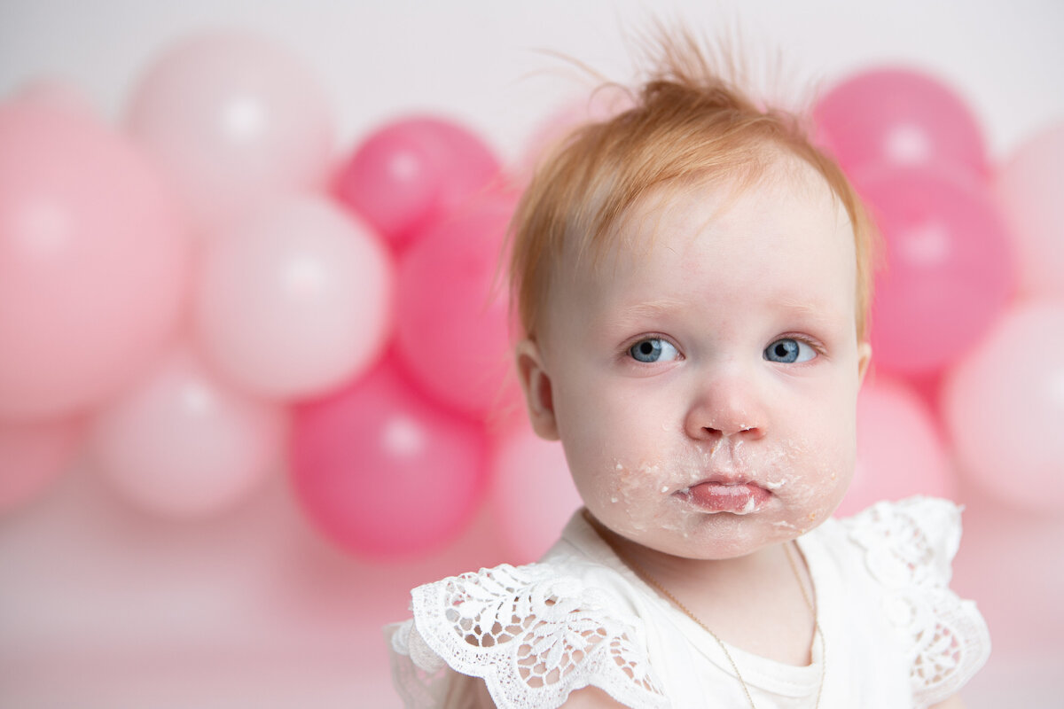 Close up baby girl with pink balloons