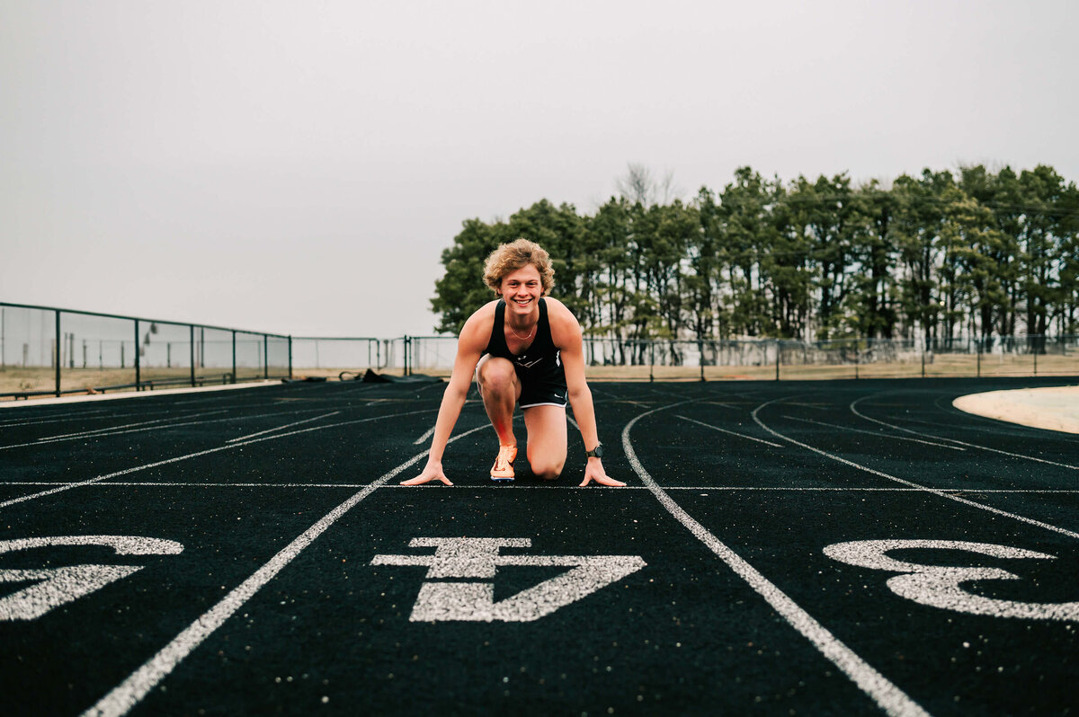 high school senior racing on track during Branson Missouri senior photographer Jessica Kennedy of The XO Photography