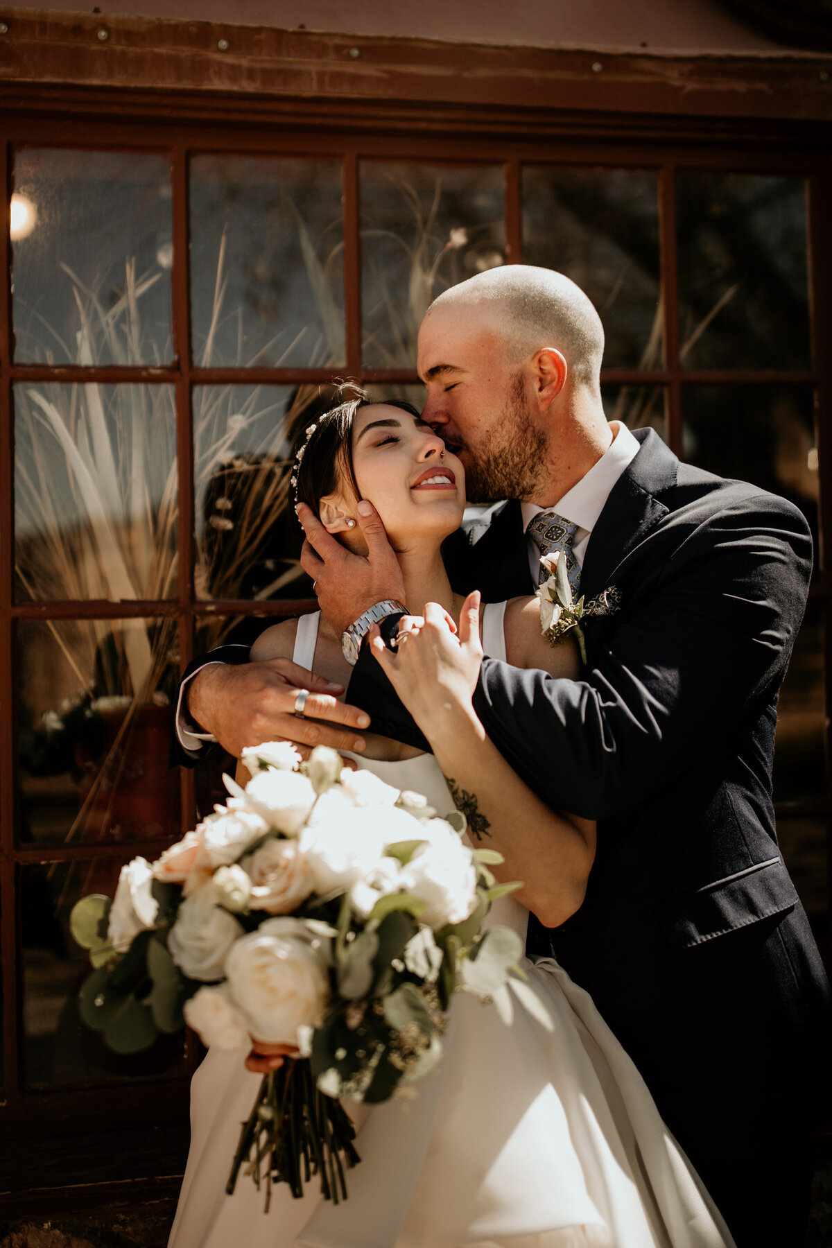 groom kissing smiling bride