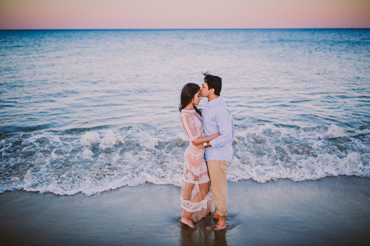 A couple sharing a moment in front of the ocean in long branch beach in nj