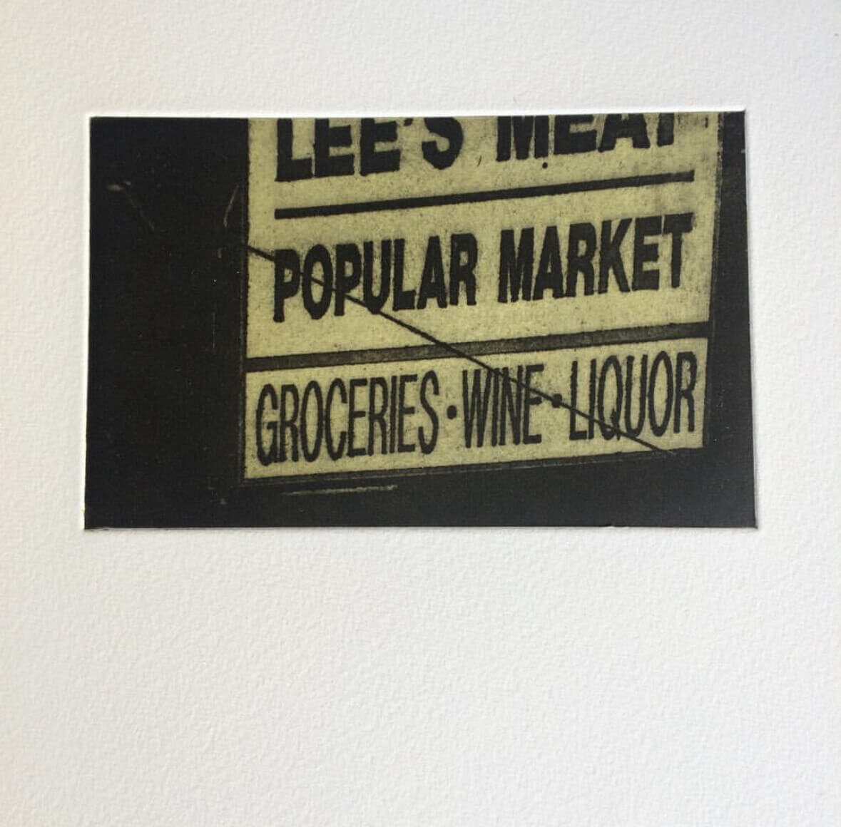 A toner transfer print of a vintage grocery store sign reading “LEE’S MEAT - POPULAR MARKET - GROCERIES • WINE • LIQUOR.”