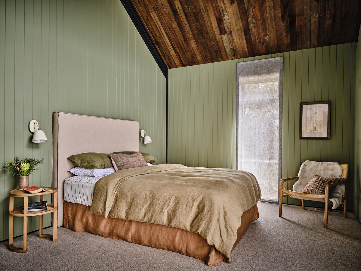 Warm and inviting bedroom design with mixed textures, timber ceiling and sage green walls, styled by Melbourne interior designer Lisa Hunter.