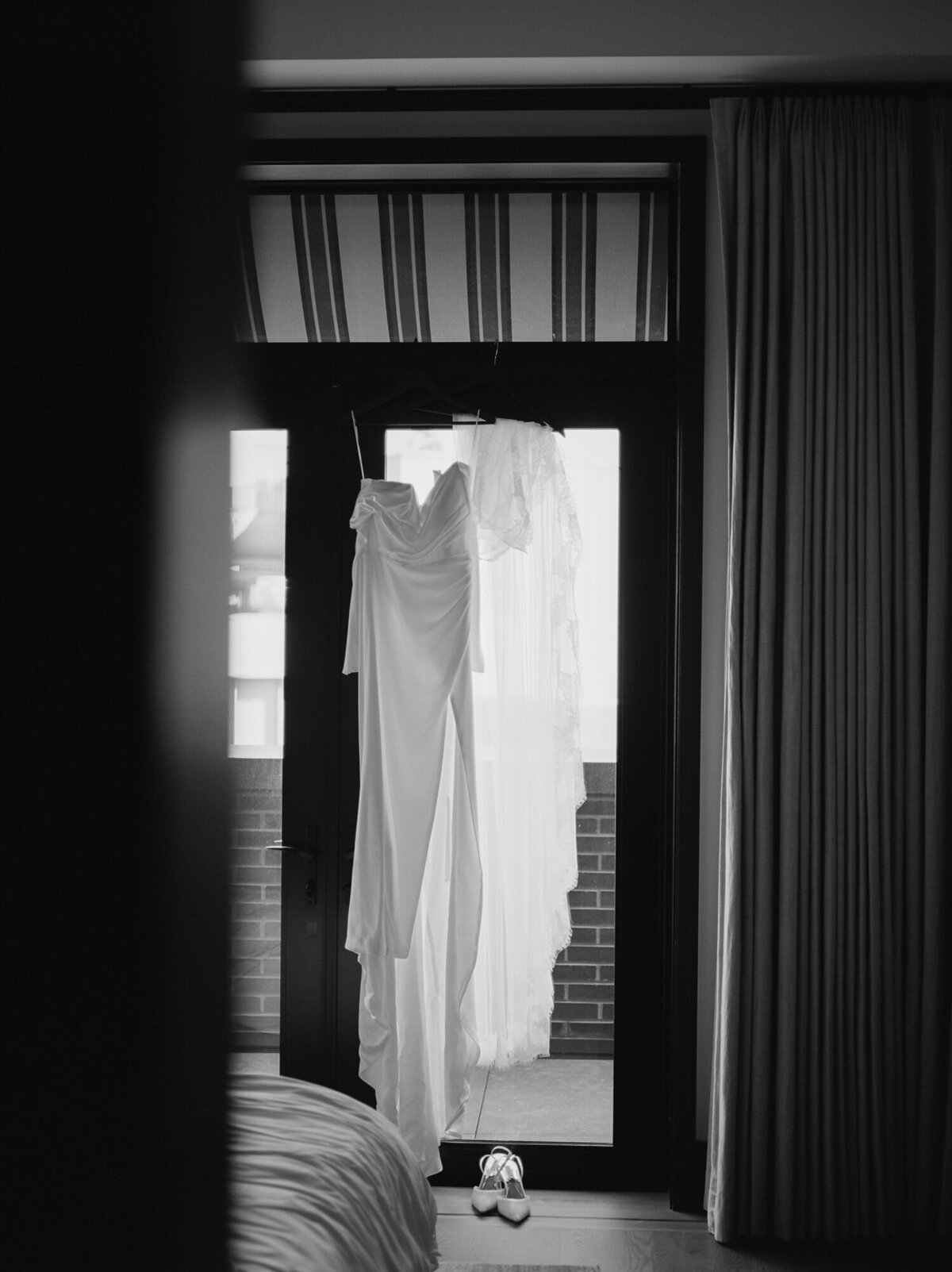 a silky asymmetrical wedding dress hangs at Shinola Hotel, Detroit