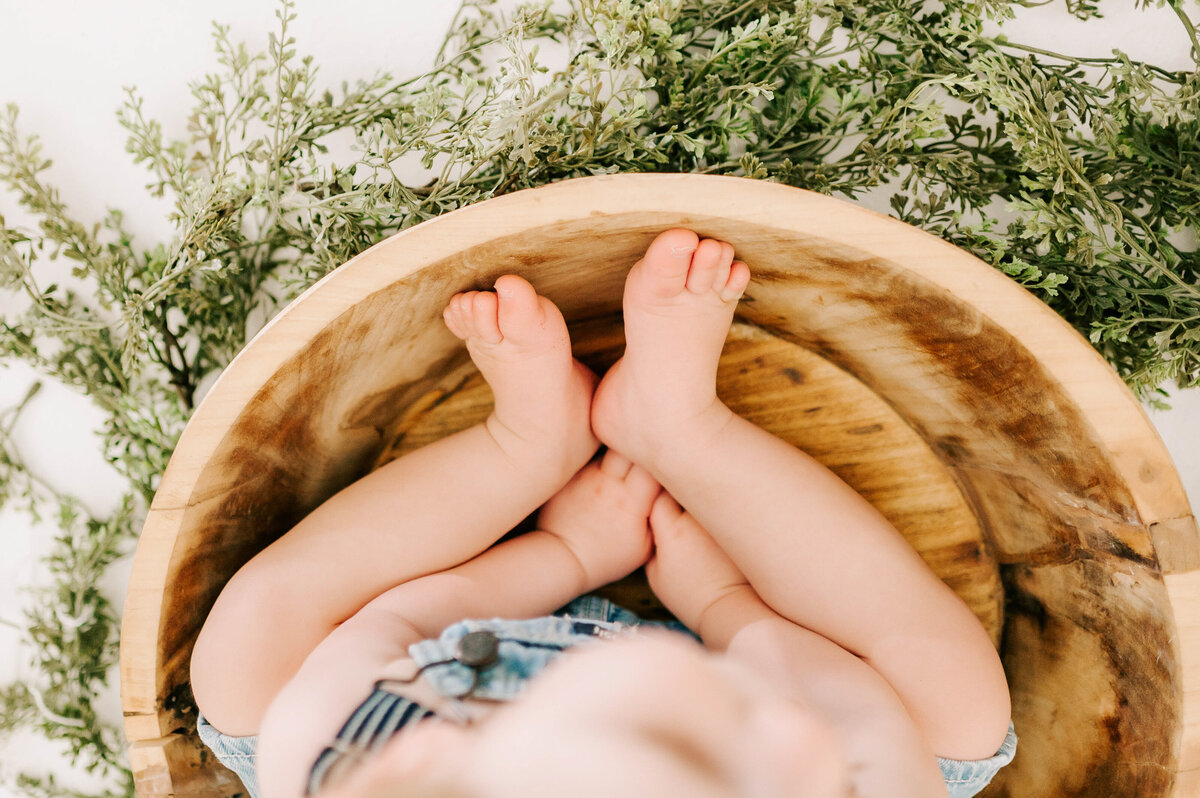 close up of baby toes and hands in bowl 