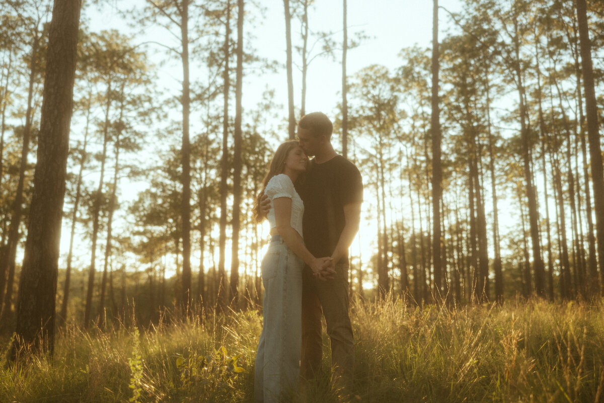 Couple posing for portraits in a forest.