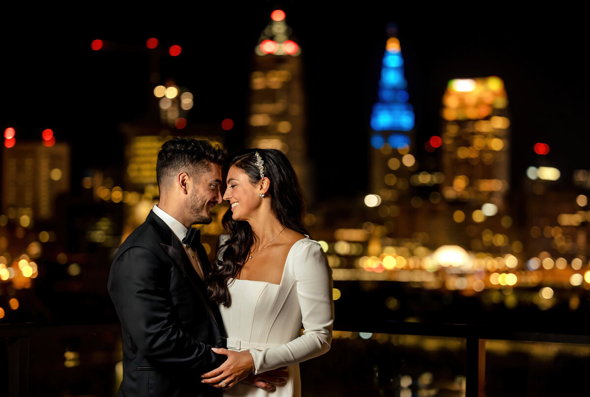A couple looks at each with the Cleveland skyline behind them at their Truss wedding.