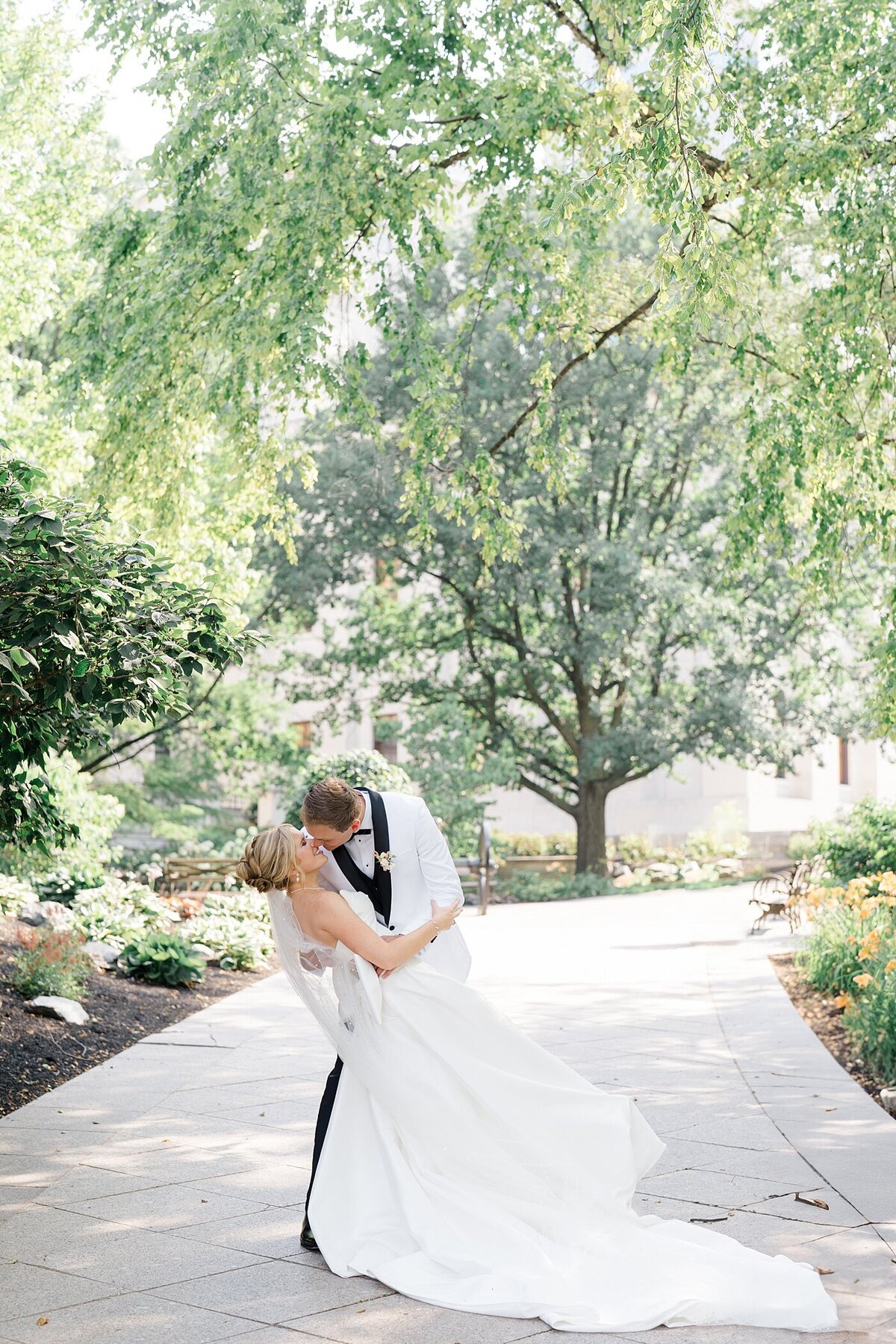 groom dipping his bride backwards and kissing her passionately on a path in a garden at the Westin wedding venue