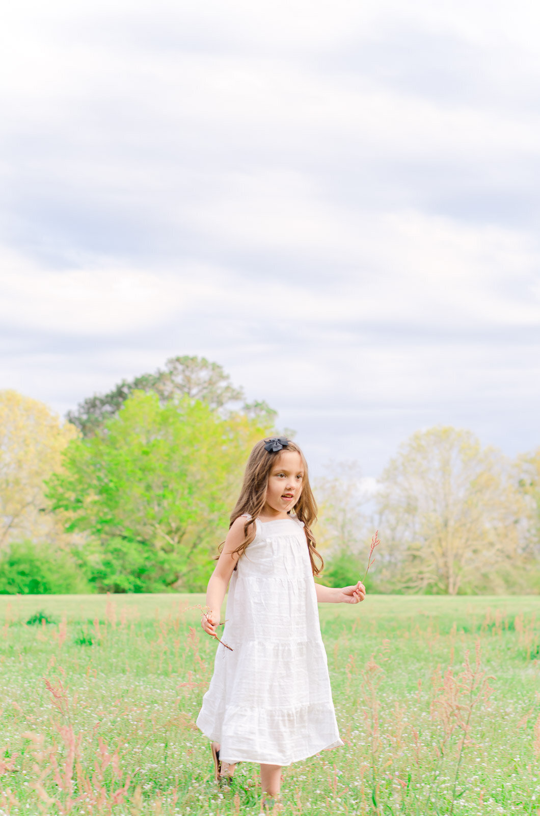 girl in white dress runs in field