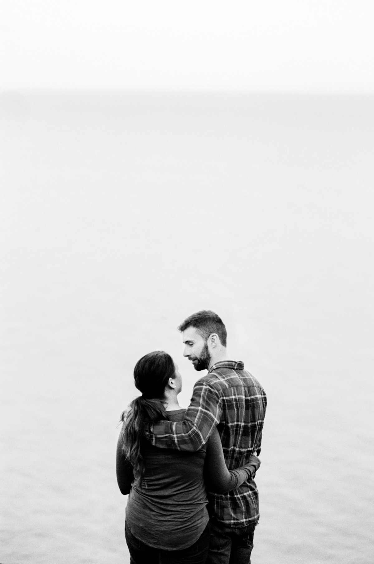 couple stands high above lake superior with no visible horizon