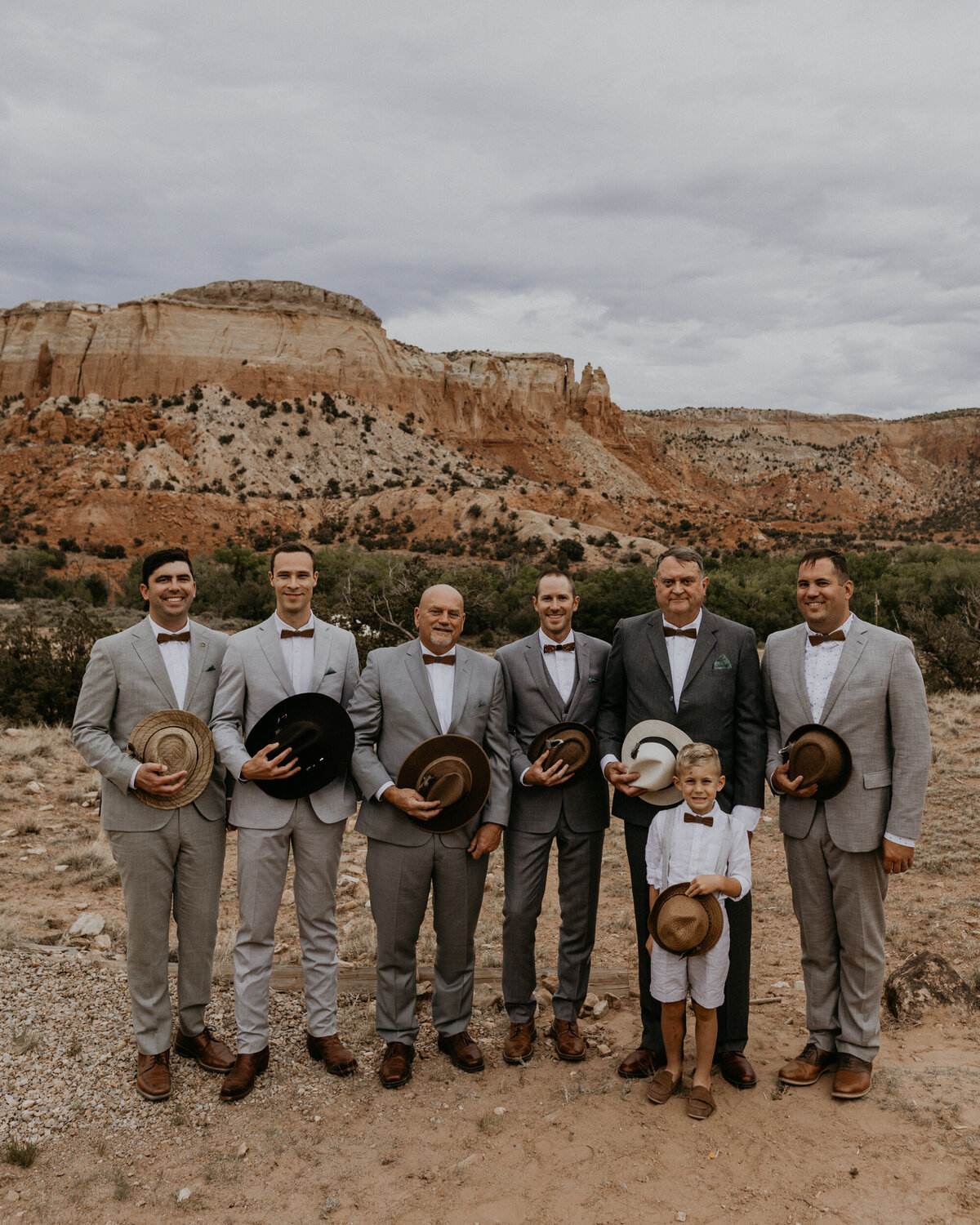 groom and groomsmen in front of red rocks