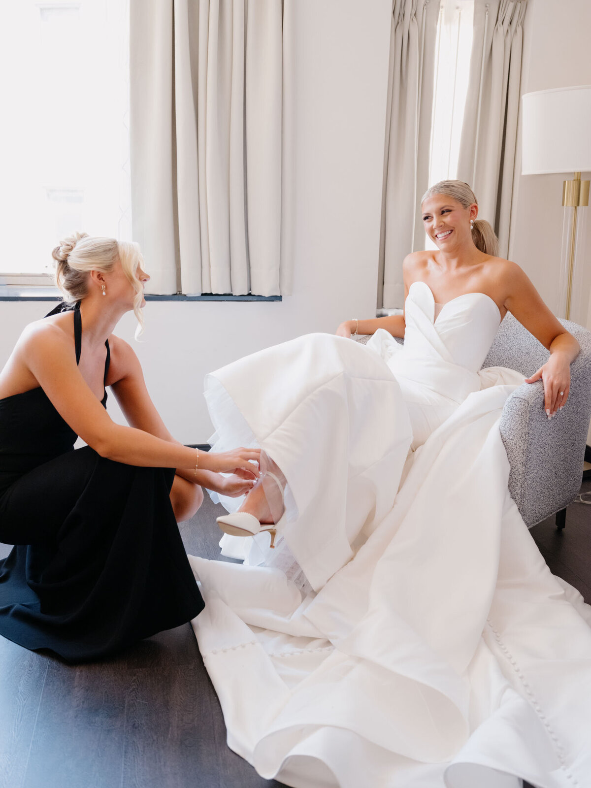Bride's sister putting her wedding shoes on at The Hotel Indigo in Cleveland