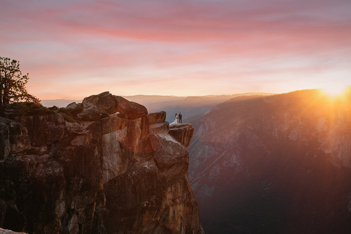 A bride and groom enjoy a sunset on their wedding day from the epic view at Taft Point in Yosemite National Park.