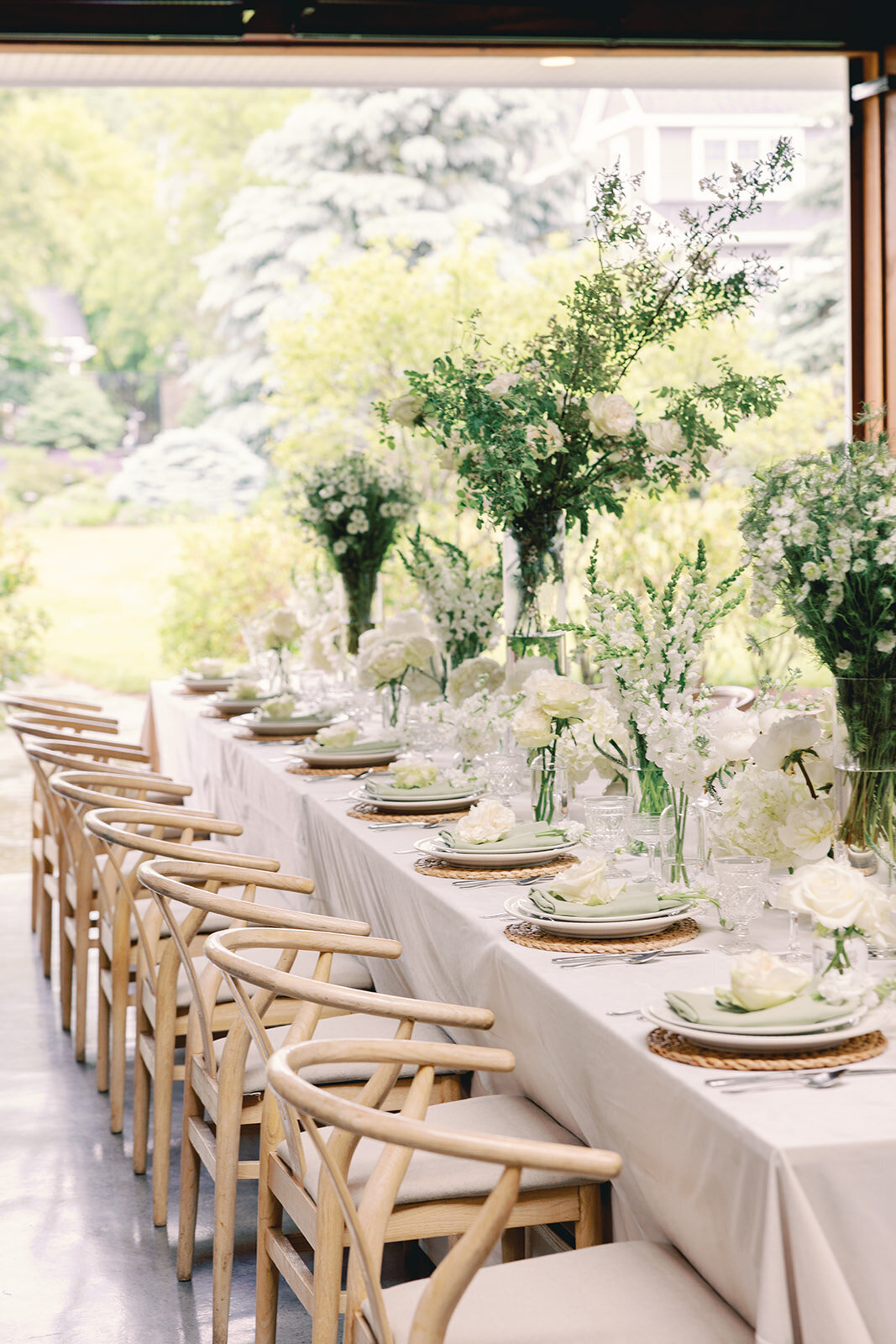 Table setting with white tablecloth and white and green floral centerpieces