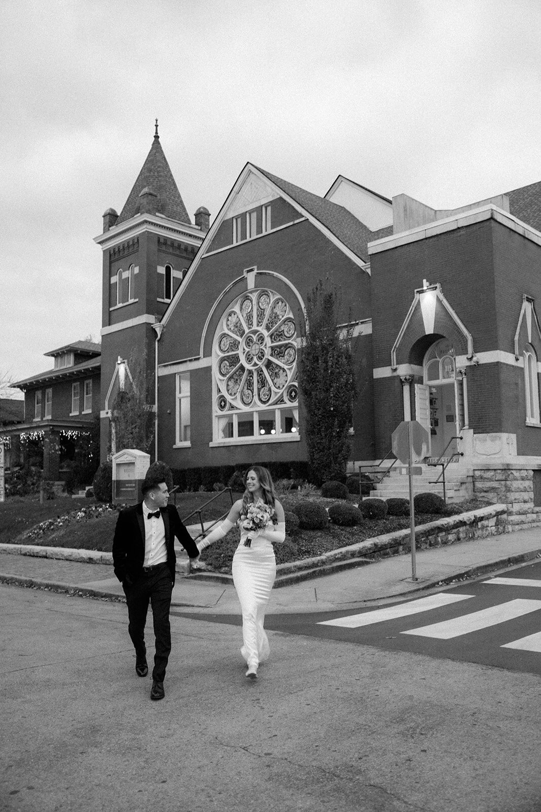 Bride and groom walk across the street in downtown Nashville after their wedding ceremony.
