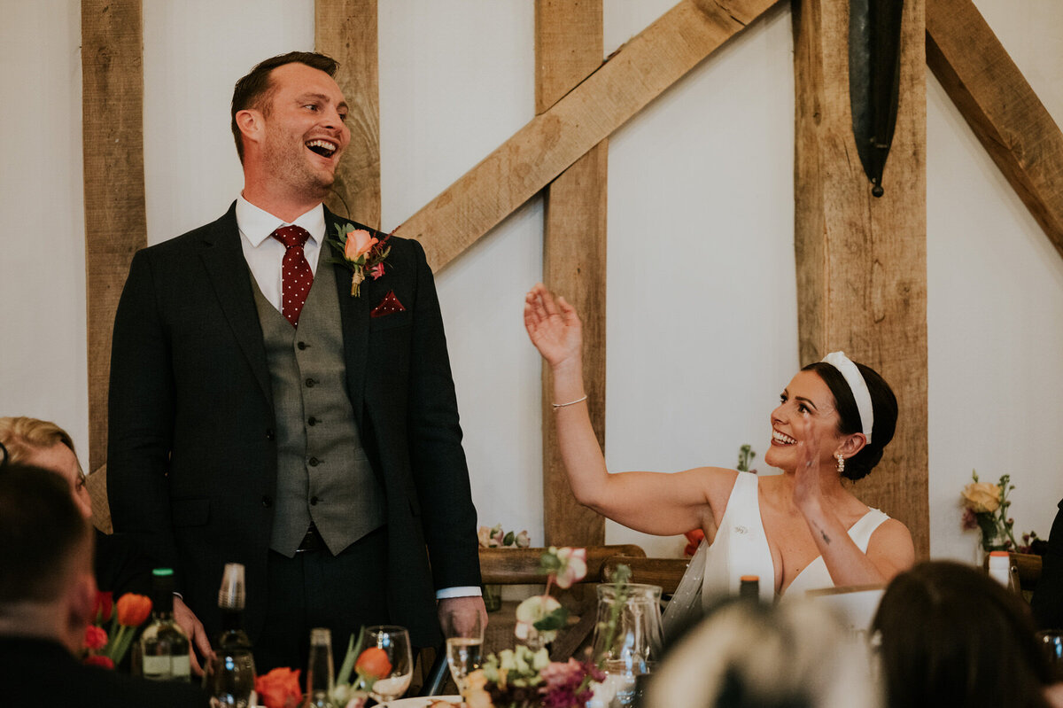 Bride and groom laughing during the grooms speech