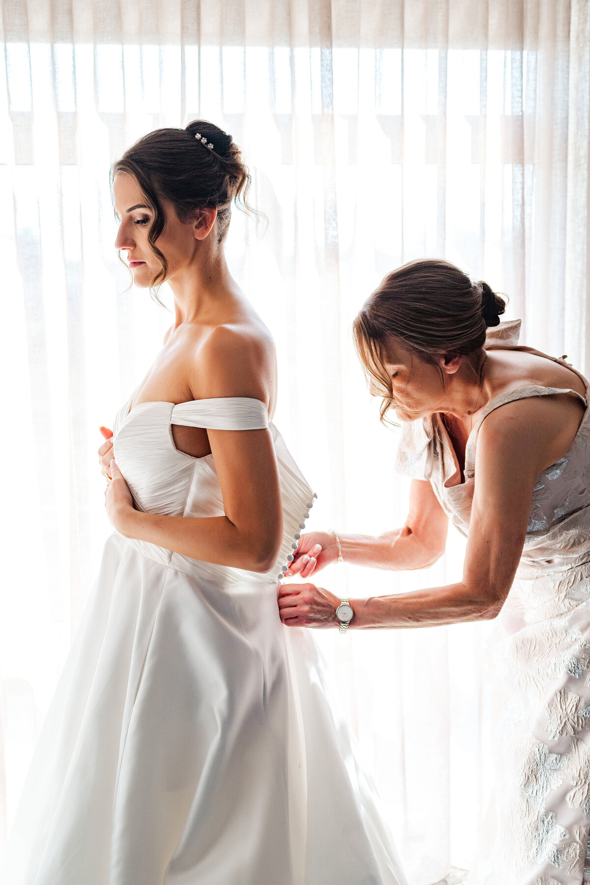 mom zipping up daughters wedding dress during youngstown wedding