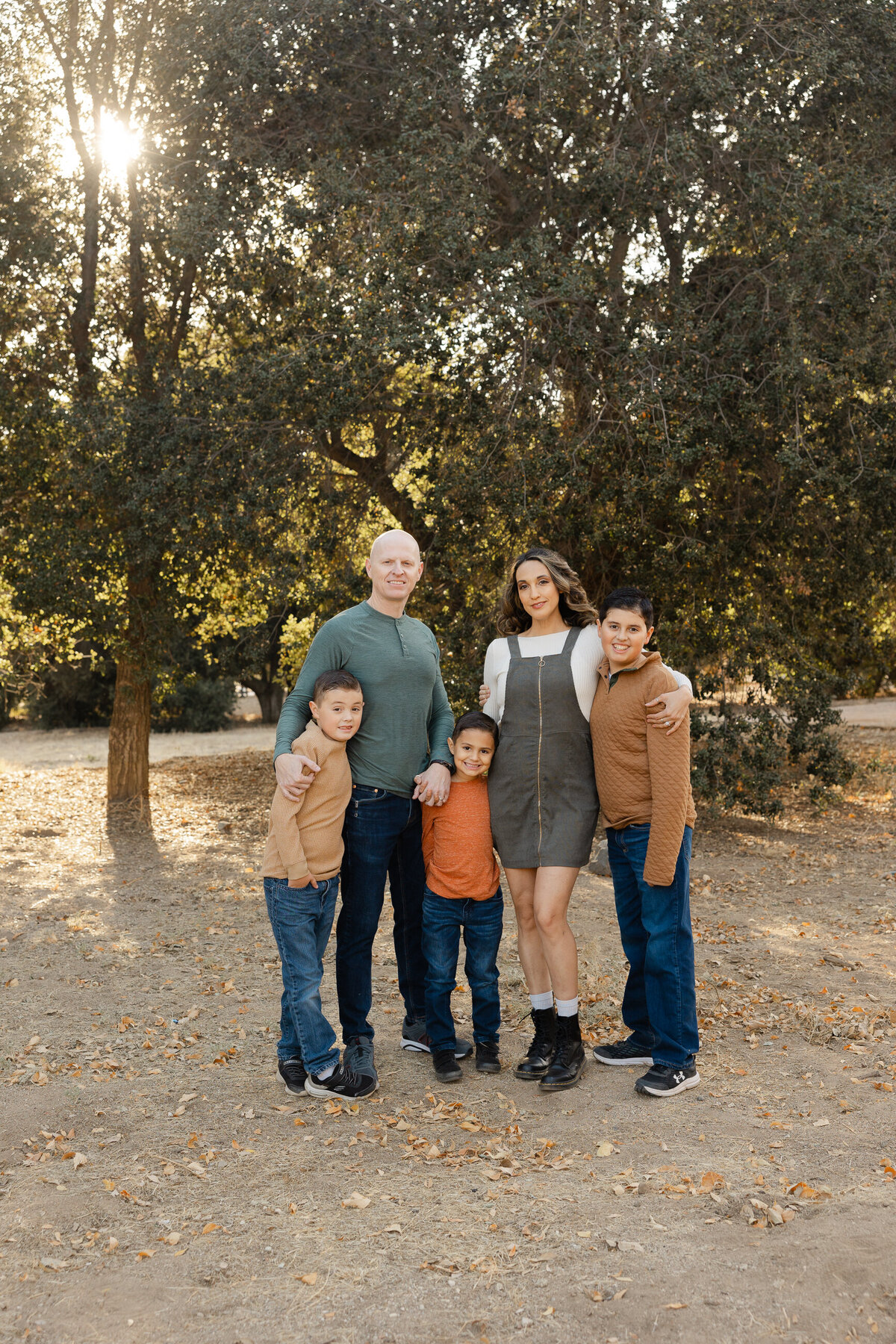 Parents standing with their two children in matching jeans and boots during autumn session. Photographed by Yucaipa family photographer Kaitlyn Dawn Photography.