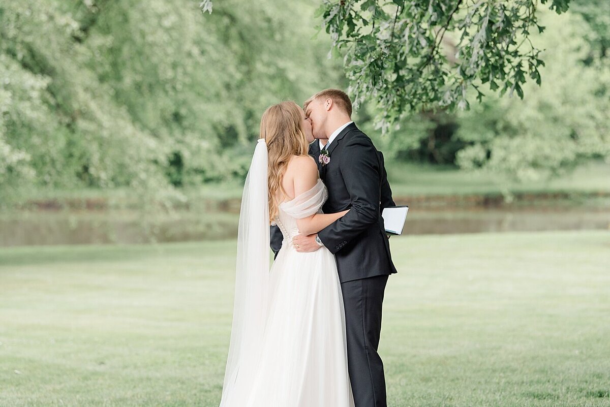bride and groom kissing during ceremony at beverly mansion