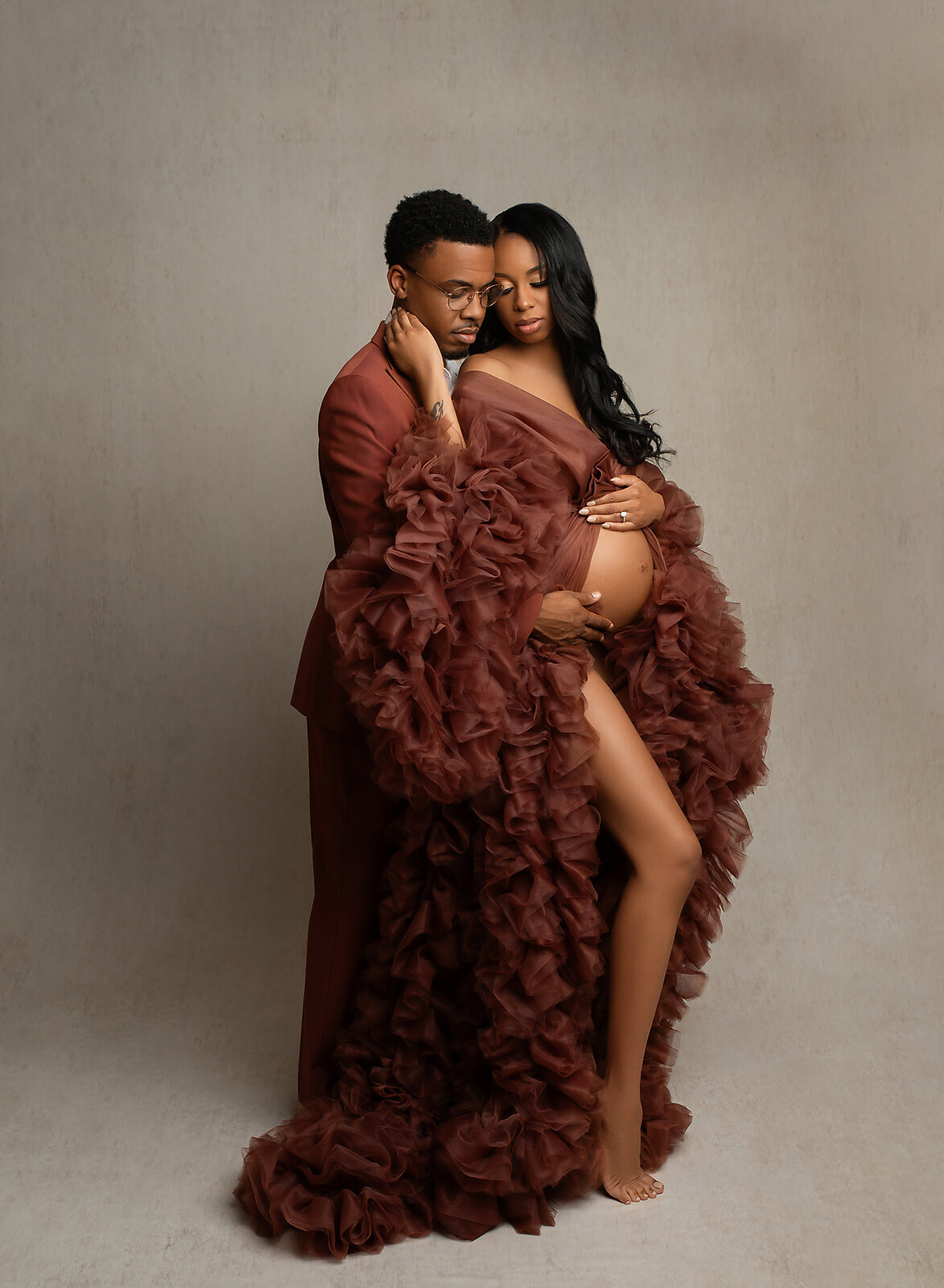 cute maternity couple studio photoshoot in rust color